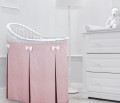 Mobile wicker bed with pink skirt